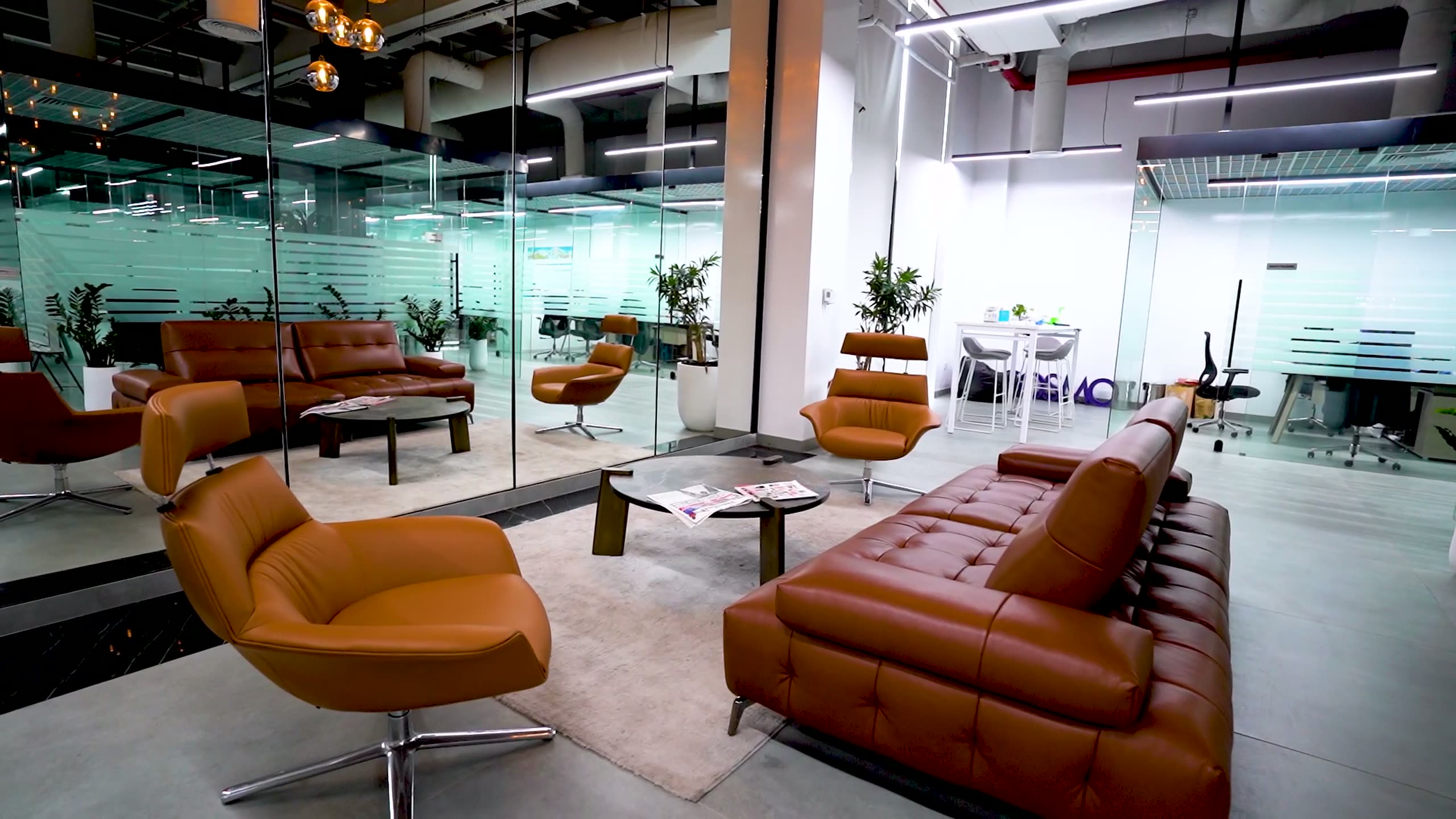 A Wright Brothers office fit-out: leather lounge seating beside glazed partitions under exposed services